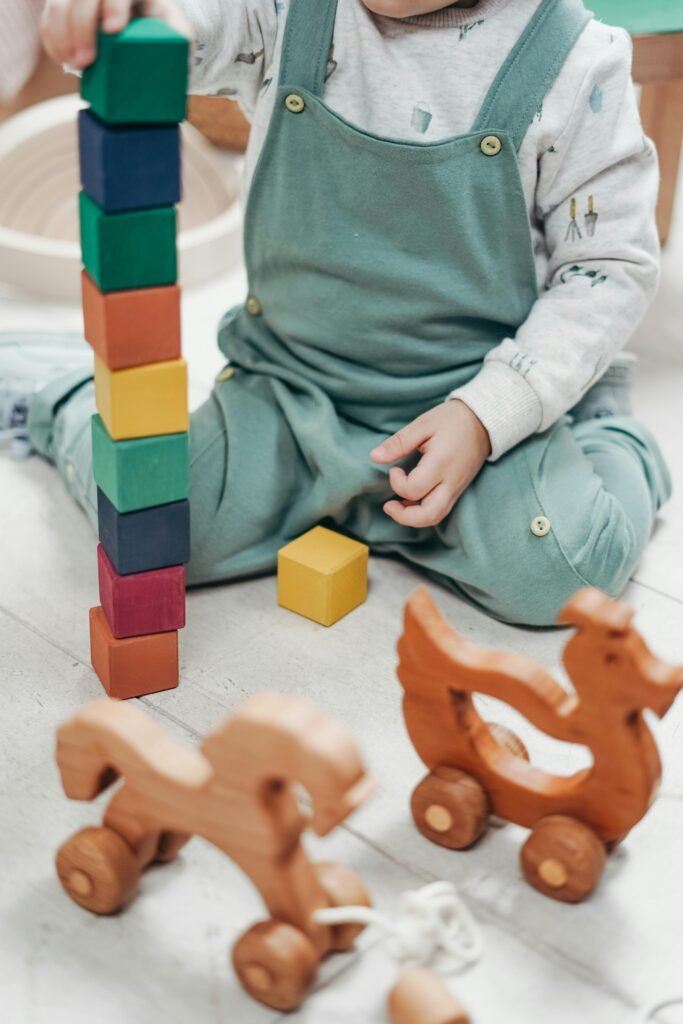 Toddler stacking small, colourful wooden blocks.
